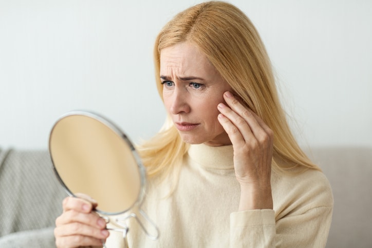 Anti-Wrinkle Skin Care. Sad Woman Looking In Mirror